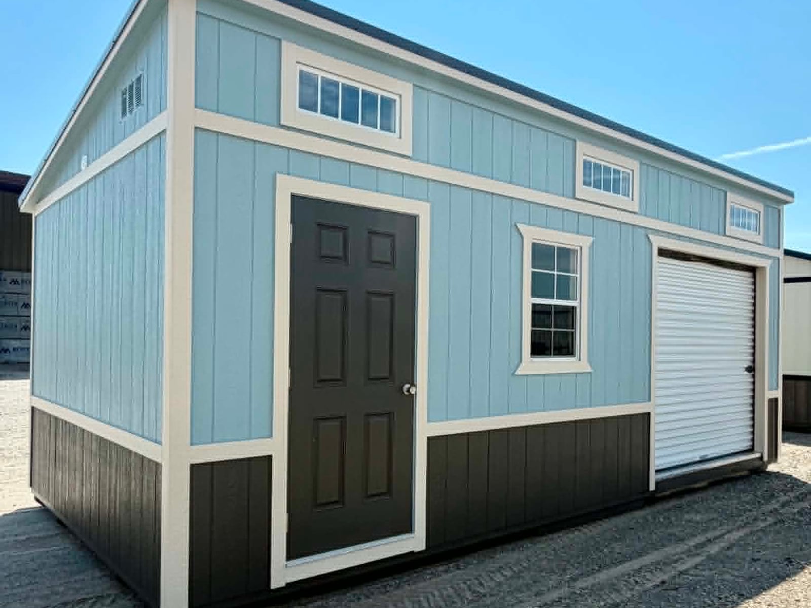 Light blue Burnett studio shed with a single-slope roof, transom windows and a roll-up door