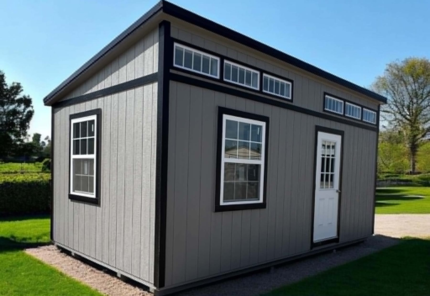 Grey Burnett studio shed with a single-slope roof, black trim and a row of clerestory transom windows