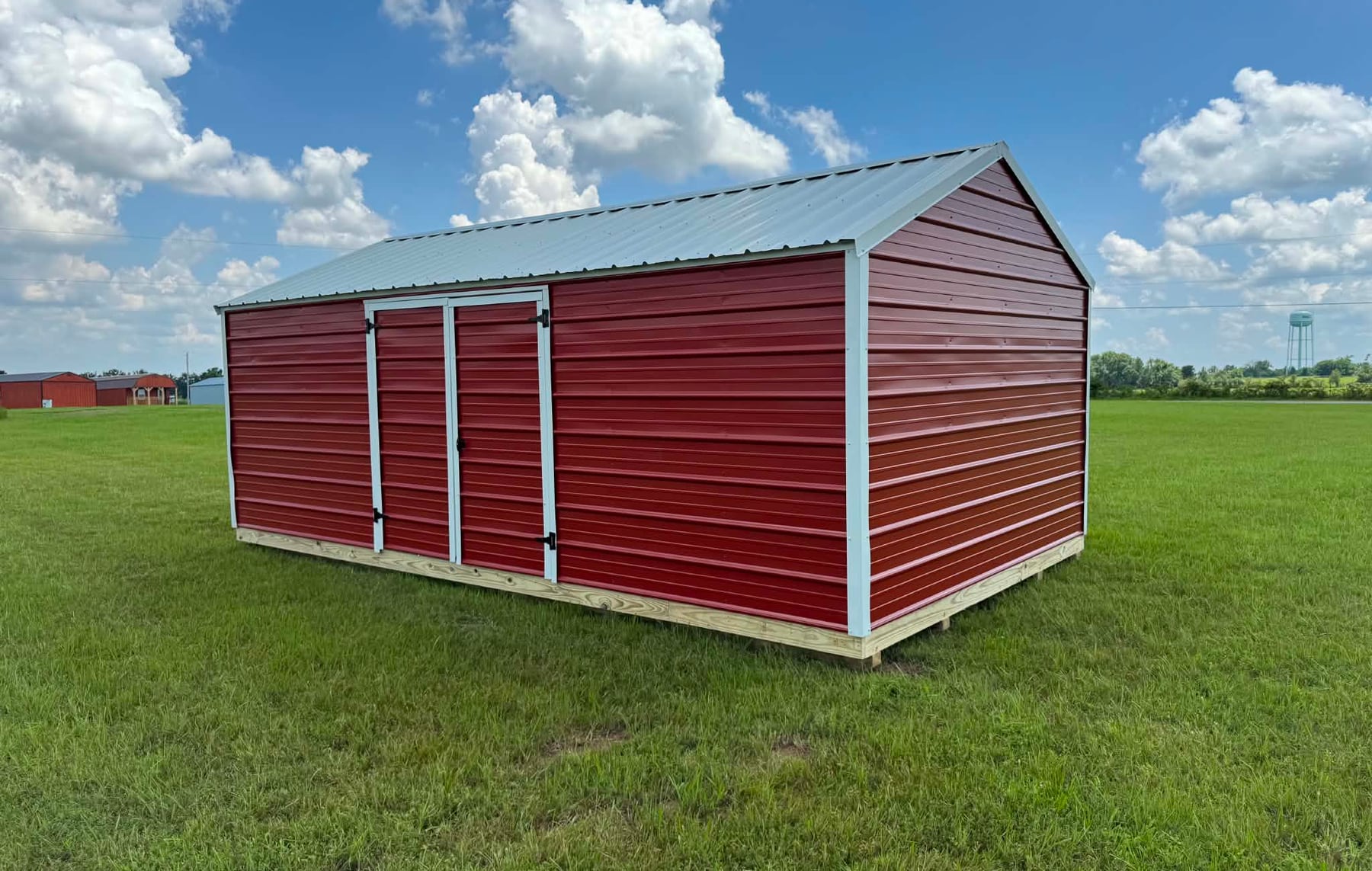 Red metal Side Value Shed with double doors on the long side wall, white trim and a galvanized roof